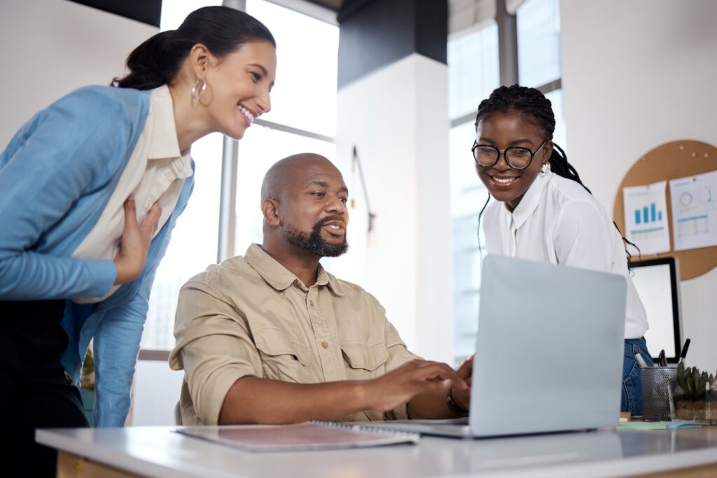 Business has been blosomming. Shot of a group of businesspeople using a laptop in a modern office.