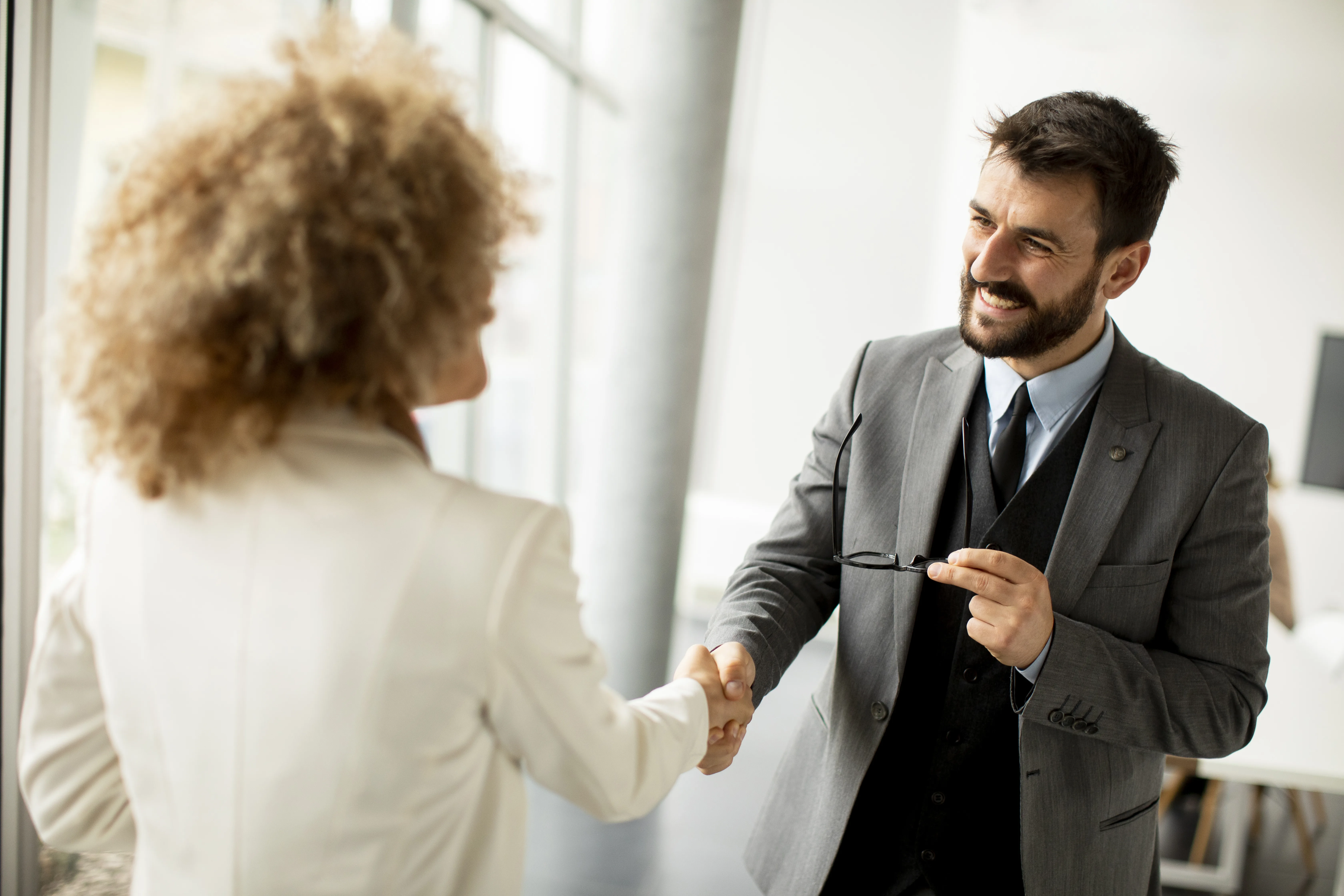 Couple of multiethnic business people handshaking in the office